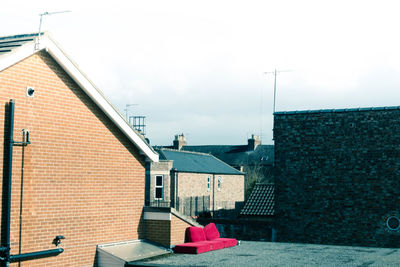 Houses by street against sky in city