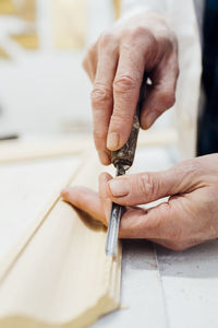 Craftsman carving wooden frame in workshop