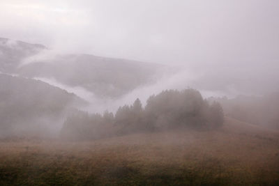 Scenic view of landscape against sky during foggy weather