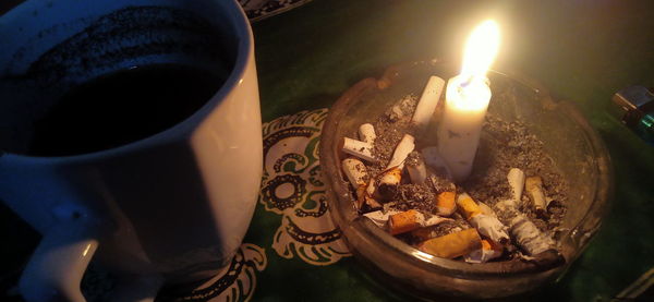 High angle view of lit candles on table