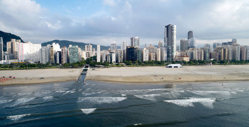 Scenic view of beach and buildings against sky