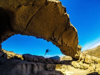 Low angle view of rock formation against clear blue sky