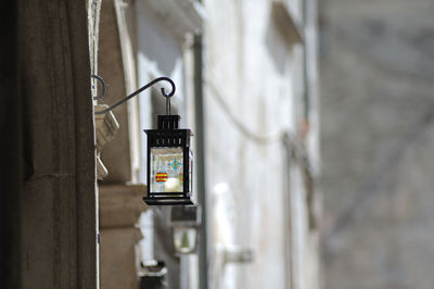 Close-up of electric lamp hanging on wall