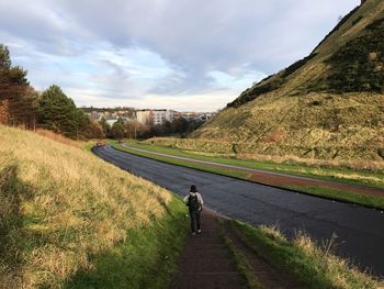 Rear view of man walking on road