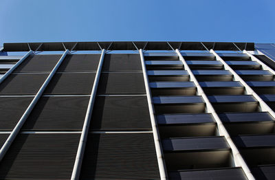Low angle view of modern building against clear blue sky