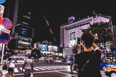 People walking in illuminated city at night