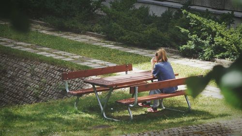 Woman sitting on bench in park