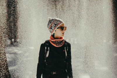 Young woman standing amidst snow