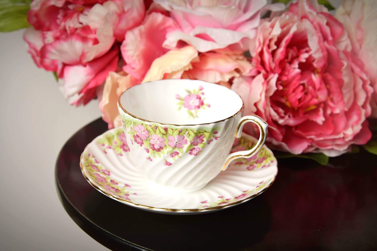 CLOSE-UP OF PINK ROSES IN POT ON TABLE AT HOME