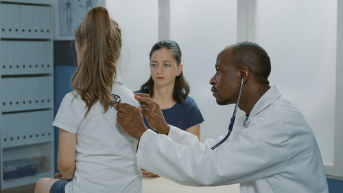 Side view of doctor examining patient in hospital