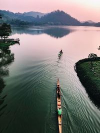 People on lake against sky