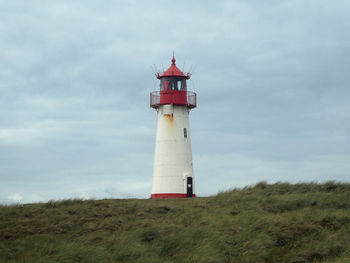 Lighthouse on shore against sky