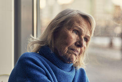 Senior woman looking through window