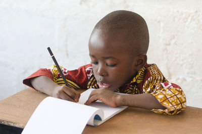 Portrait of boy sitting on table