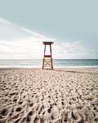 Lifeguard hut on beach against sky