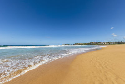 Scenic view of beach against blue sky