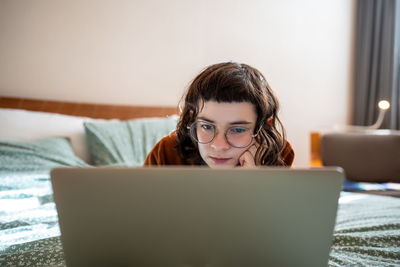 Thrilled interested teen girl watching film on laptop computer, spending weekend, pastime at home