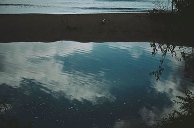 Reflection of man swimming in sea