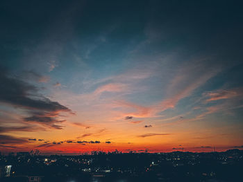 Scenic view of dramatic sky over city during sunset