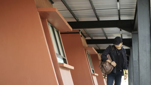 Full length of man standing against building