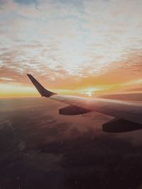 Airplane on beach against sky during sunset