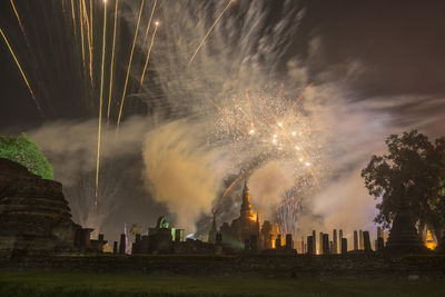 Firework display against sky at night