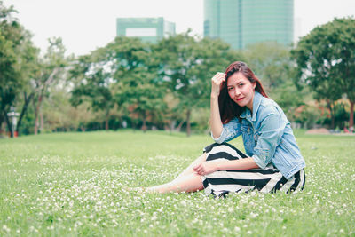 Portrait of smiling young woman sitting in park