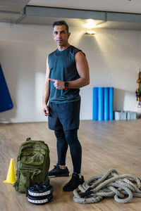 Full length portrait of man standing against wall