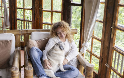 Portrait of young woman sitting on sofa at home