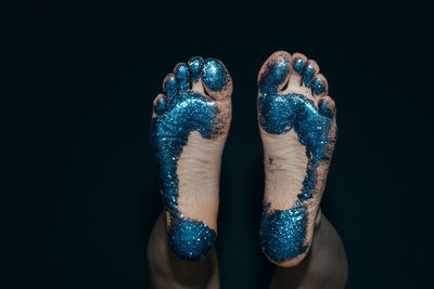 Low section of woman with glitter over gray background