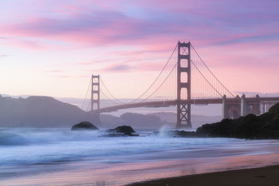 View of suspension bridge against cloudy sky