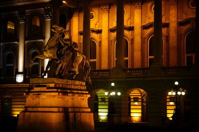 Statue in city at night