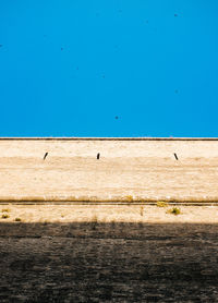 Low angle view of building against clear blue sky on sunny day