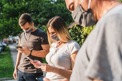 Rear view of man and woman using mobile phone