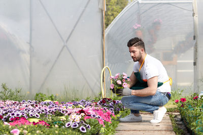 Young man smiling by flowering plants