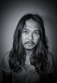 Close-up portrait of young man against wall