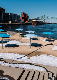 Scenic view of swimming pool by sea against clear blue sky