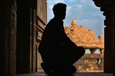 Man kneeling on entrance of historic building