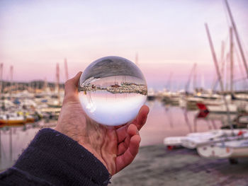 Close-up of hand holding sea against clear sky