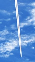 Low angle view of airplane flying against blue sky