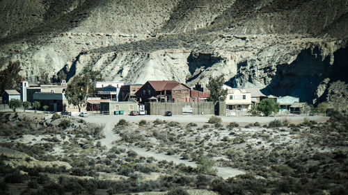 Houses on field by mountain