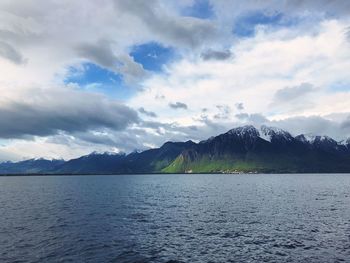 Scenic view of lake by mountains against sky