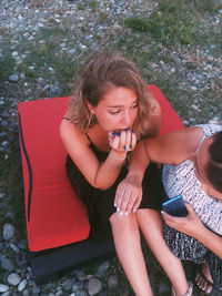 High angle view of woman looking away while sitting on mobile phone