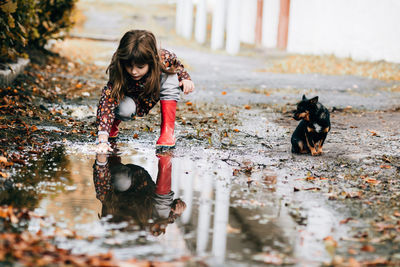 Boy playing with dog in water