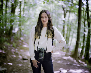 Portrait of young woman standing in forest