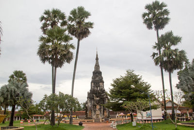 Palm trees outside temple against sky