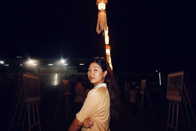 Side view portrait of young woman at art studio at night