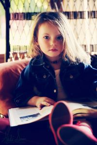 Portrait of girl sitting on book