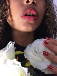 Close-up of woman holding red flower