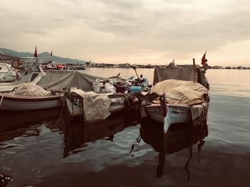 Boat moored on beach against sky during sunset